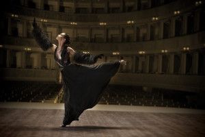 Dancer in a black gown on the stage of an old theatre, Sur la Terre inTown, 2011