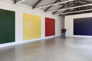 Artist Olivier Mosset in a gallery with green, yellow, red and blue monochromes, Milan 2009