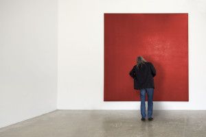 Artist Olivier Mosset facing a red monochrome painting, Milan 2009
