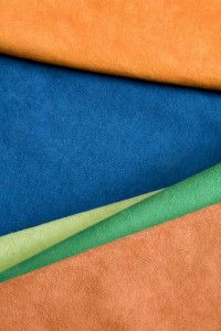 Alcantara fabric swatches in blue, green and orange, commercial