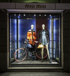 Miu Miu shop window with mannequins and a bicycle at night, via della Spiga, Milan