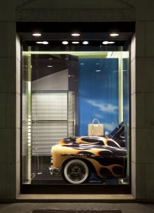 Prada shop window with a flame-painted hot rod car, via Montenapoleone, Milan