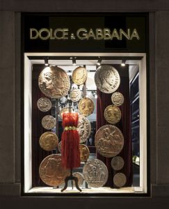 Dolce & Gabbana shop window with red dress and large antique coins, Milan