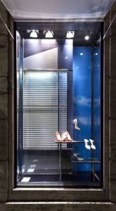 Prada shop window with shoes against a blue sky backdrop, via Montenapoleone, Milan