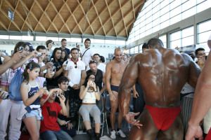 Bodybuilder posing in front of a crowd at a fitness expo