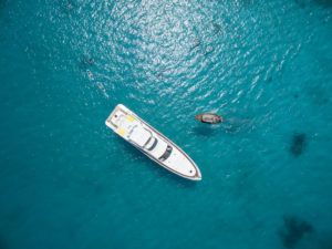 Motor yacht anchored in a turquoise lagoon, Cheval Blanc Randheli, Maldives, aerial view