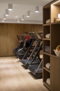 Fitness room with treadmills and wooden shelves, White 1921 hotel, Courchevel