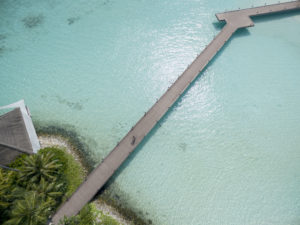 Wooden jetty over the shallow lagoon, Cheval Blanc Randheli, Maldives, aerial view