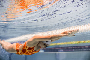 Swimmer in an orange suit streamlined underwater, arena Water Instinct S/S 2018 catalogue