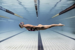 Swimmer gliding over the pool lane line, arena Water Instinct S/S 2018 catalogue